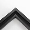 This simplistic yet modular matte black frame is designed for metal prints, acrylic prints and dry mounts. This smart design features a minimalist stepped profile that serves as a floater frame or a standard picture frame.    For the floating effect, the print can be attached on top of the inner step of the frame, without sacrificing the artwork edges.    This frame can also be used as standard picture frame. The lowered center paired with slightly raised outer lip creates a frame within a frame effect. However, due to the inner most lip of the frame, a fraction of the artwork will be hidden. But, this can be avoided with a linen liner combo.