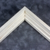 Simple tiered 1 " floater. This thin, stepped floater is unstained and left the natural wood color. The top edge has an angled inner corner, sloping towards the contents of the frame. The surface has a wood grain texture.